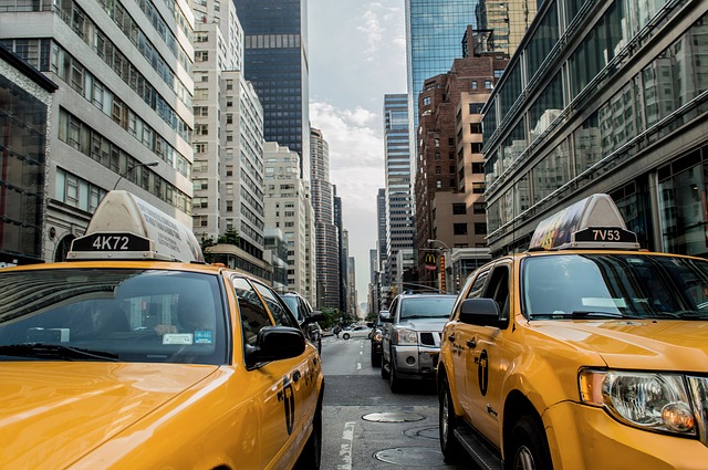 A picture of a number of taxi cars at a street